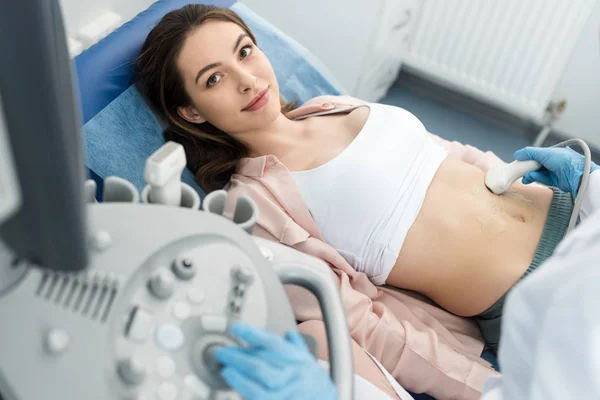 Doctor making ultrasound scan of stomach to young patient in clinic — Stock Photo