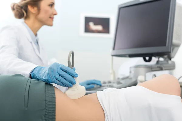 Médico profissional examinando rim e olhando para a tela em branco de ultra-som na clínica — Fotografia de Stock