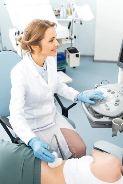 Médico profissional examinando rim de paciente do sexo feminino com ultra-som na clínica — Fotografia de Stock