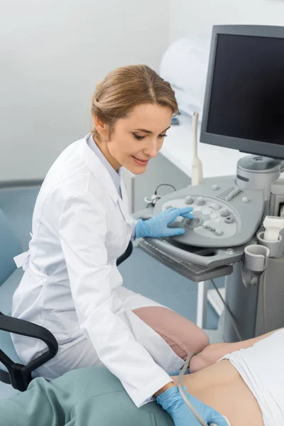 Профессиональный врач, осматривающий почки с помощью ультразвукового сканирования в клинике — стоковое фото