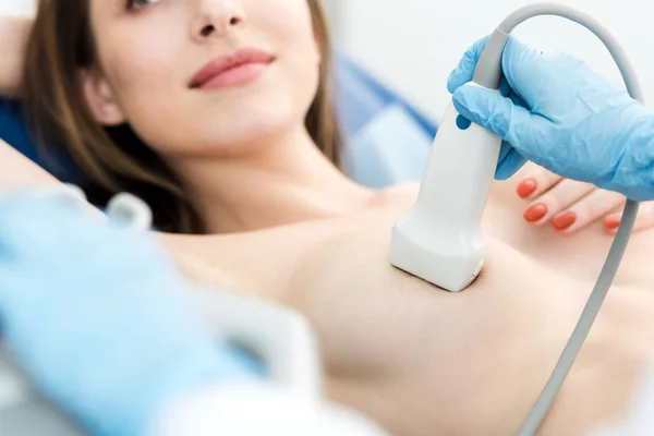 Vista recortada del médico que hace el examen de mama para la paciente utilizando el escáner de ultrasonido - foto de stock