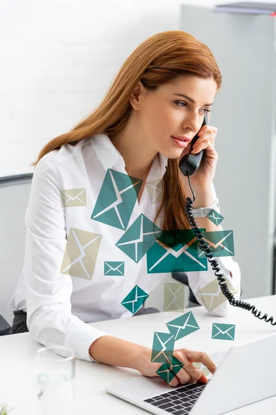 Successful businesswoman using laptop and talking on phone at office table, e-mail illustration — Stock Photo