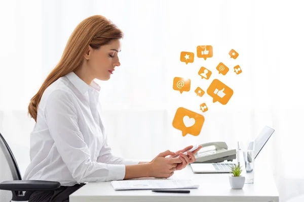 Side view of businesswoman using smartphone near documents and laptop on table, social media illustration — Stock Photo