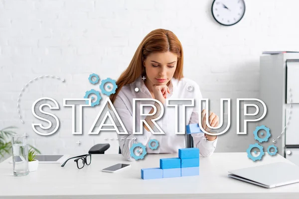 Attraktive Geschäftsfrau stapelt Marketing-Pyramide aus blauen Bausteinen auf Tisch, Start-up-Illustration — Stockfoto