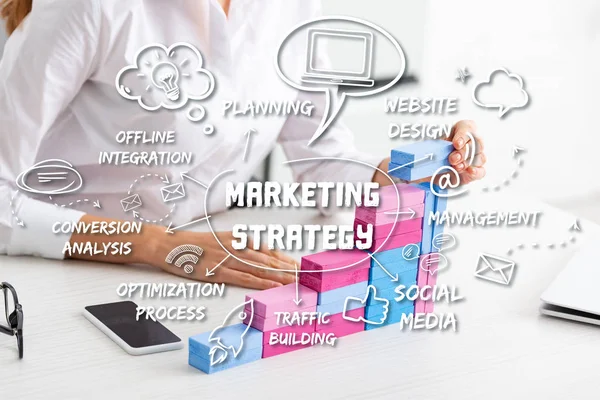 Ausgeschnittene Ansicht einer Geschäftsfrau, die Marketingpyramide aus Bausteinen auf dem Tisch stapelt, Illustration der Marketingstrategie — Stockfoto