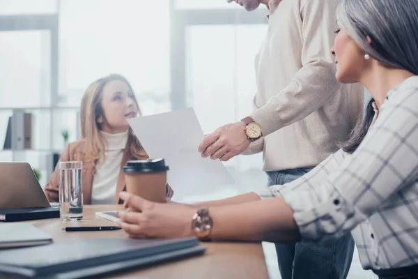 Vista ritagliata di uomo che mostra carta ai suoi colleghi in agenzia creativa — Foto stock