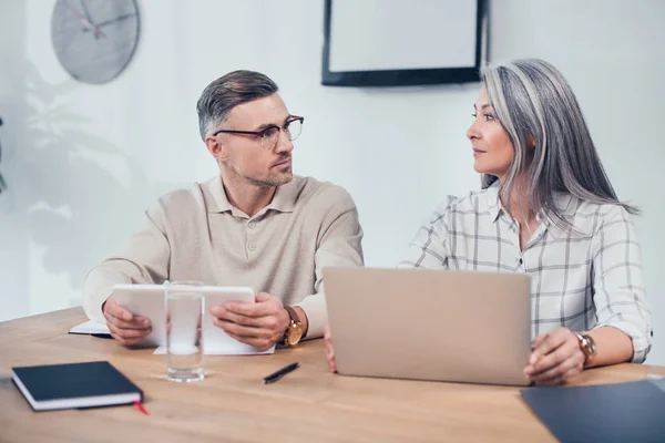 Colegas multiculturales que se miran en la agencia creativa - foto de stock