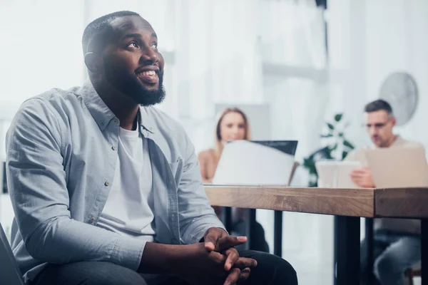 Selektiver Fokus lächelnder Afroamerikaner und Kollegen auf Hintergrund — Stockfoto