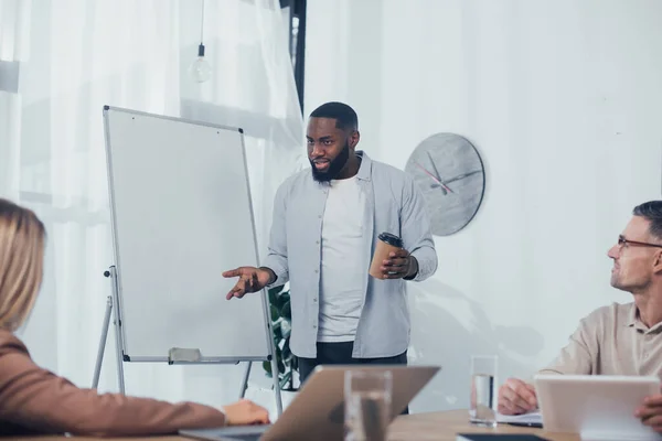 Selective focus of african american businessman talking with colleague — Stock Photo