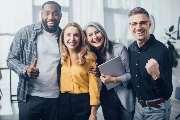 Souriant collègues multiculturels étreignant et montrant comme et oui geste — Photo de stock