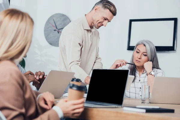 Selective focus of multicultural colleagues looking down in creative agency — Stock Photo