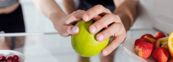 Panoramic shot of man and woman touching apple in fridge — Stock Photo