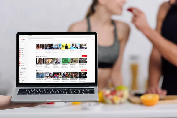 Kiew, Ukraine - 28. Dezember 2019: selektiver Fokus von Laptop mit Youtube-Website in der Nähe von Paar in der Küche — Stockfoto