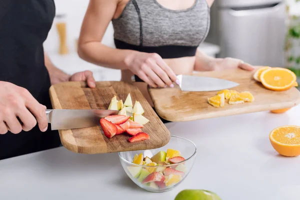 Обрезанный вид мужчины и женщины, готовящих фруктовый салат — стоковое фото