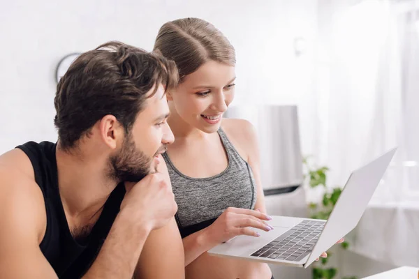 Glücklicher Mann und Frau, die zu Hause auf Laptop schauen — Stockfoto