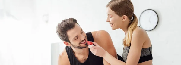 Tiro panorâmico de menina feliz alimentando o homem com morango — Fotografia de Stock