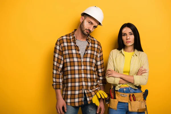 Traurige Arbeiter mit verschränkten Armen auf gelb — Stockfoto