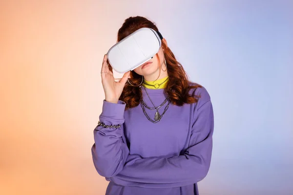 Chateado menina adolescente usando fone de ouvido realidade virtual, em roxo e bege — Fotografia de Stock