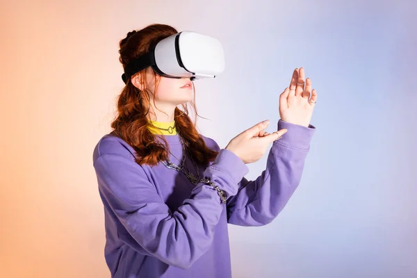 Female teenager gesturing and using virtual reality headset, on purple and beige — Stock Photo