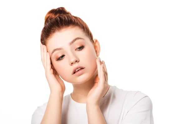 Atractiva adolescente femenina con el pelo rojo tocando la cara, aislado en blanco - foto de stock
