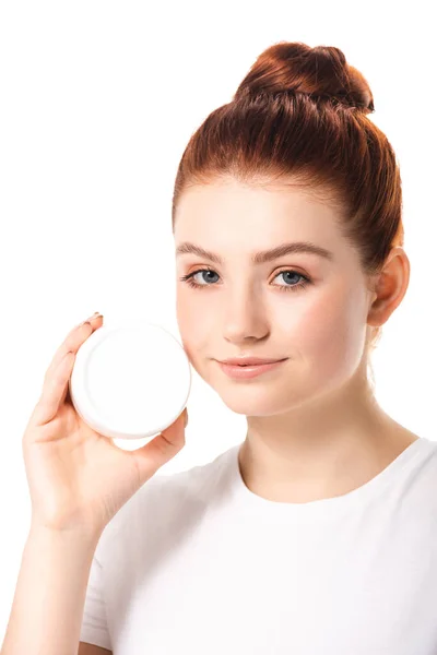 Bela menina adolescente positiva com pele perfeita segurando recipiente de plástico com creme cosmético, isolado no branco — Fotografia de Stock