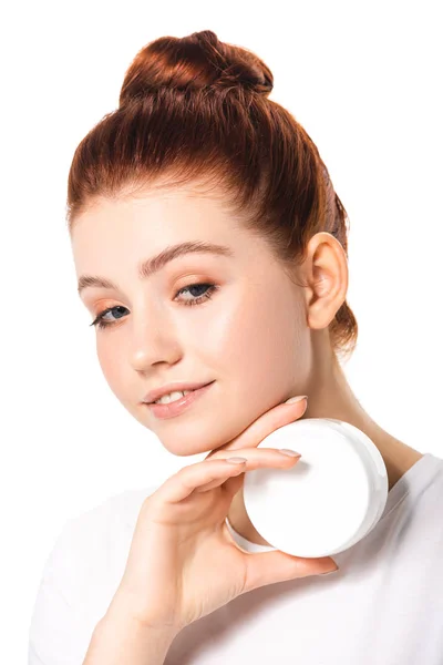 Smiling teen girl holding plastic container with cosmetic cream, isolated on white — Stock Photo