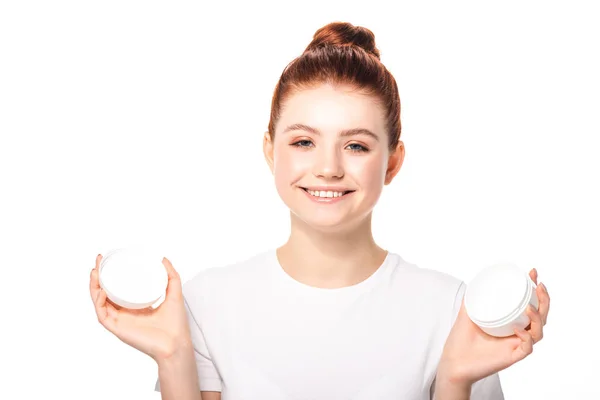 Adolescente positivo com pele perfeita segurando recipiente de plástico com creme cosmético, isolado em branco — Fotografia de Stock