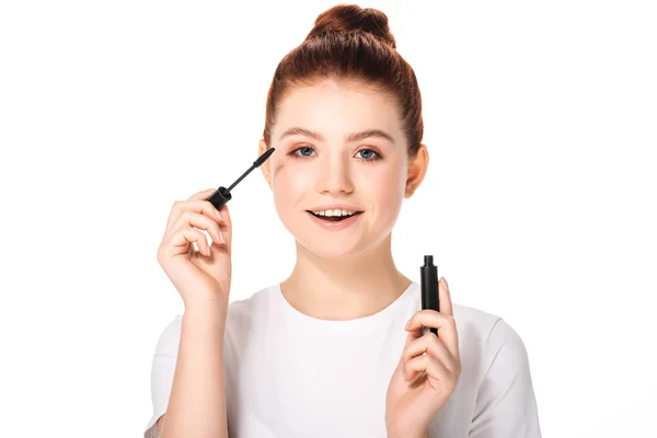 Aufgeregter weiblicher Teenager, der Mascara aufträgt, isoliert auf weiß — Stockfoto