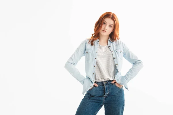 Bella ragazza rossa adolescente in abiti di jeans con gesto akimbo, isolato su bianco — Foto stock