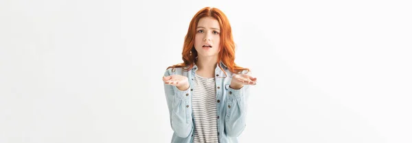 Panoramic shot of worried teen girl in denim clothes with shrug gesture, isolated on white — Stock Photo