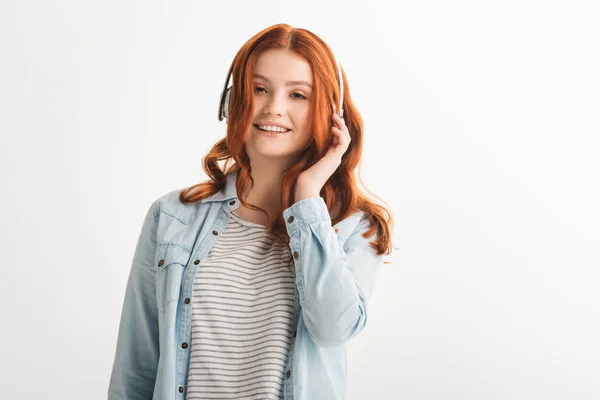 Fröhlich attraktive rothaarige Teenie-Mädchen Musik mit Kopfhörern hören, isoliert auf weiß — Stockfoto