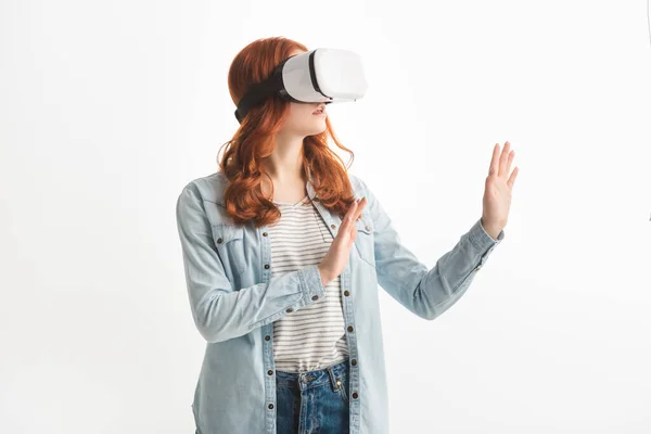 Bonito ruiva adolescente gestos e usando realidade virtual fone de ouvido, isolado no branco — Fotografia de Stock
