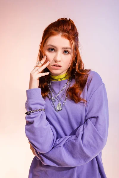 Beautiful bored redhead teen girl, on purple and beige — Stock Photo