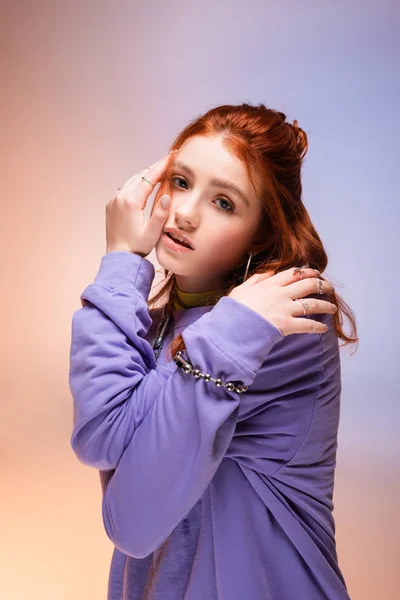 Atractiva chica adolescente pelirroja aburrida, en púrpura y beige - foto de stock
