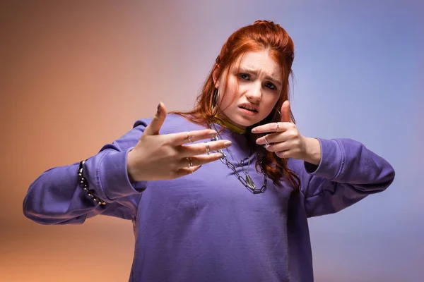 Angry female teenager gesturing in bad mood, on purple and beige — Stock Photo