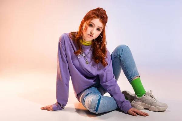 Красива сумна дівчина-підліток сидить на фіолетовому і бежевому — стокове фото