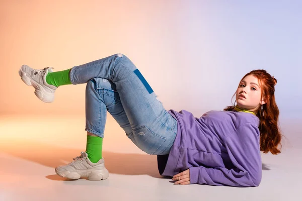 Schöne traurige Teenie-Mädchen mit roten Haaren, auf lila und beige — Stockfoto