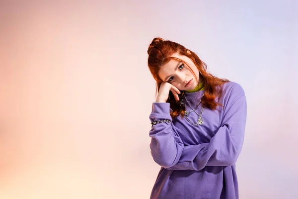 Beautiful bored redhead teen girl, on purple and beige — Stock Photo