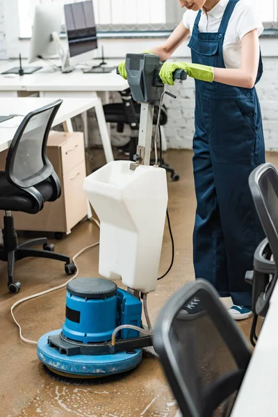 Cropped view of cleaner washing floor in office with cleaning machine — Stock Photo