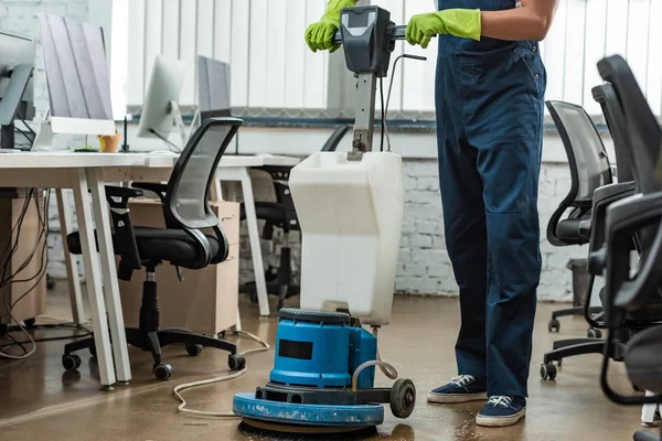 Cropped view of cleaner washing floor in office with cleaning machine — Stock Photo