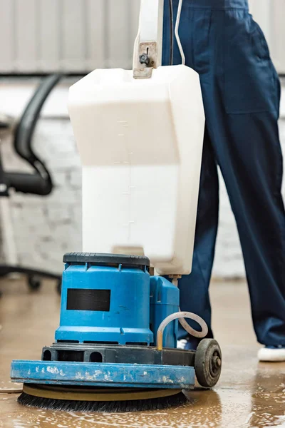 Cropped view of cleaner washing floor in office with cleaning machine — Stock Photo