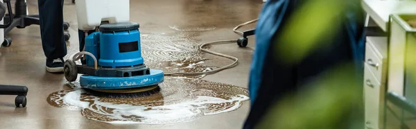 Cropped view of cleaner washing floor with cleaning machine, panoramic shot — Stock Photo