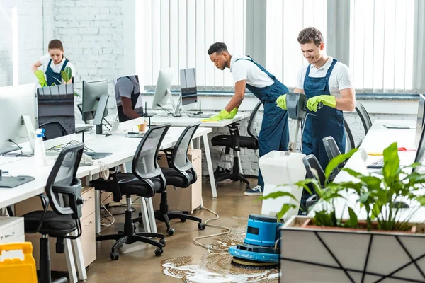 Multicultural team of cleaners working in modern open space office — Stock Photo