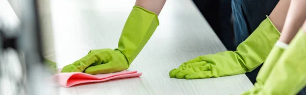 Vista ritagliata di detergente in guanti di gomma scrivania di lavaggio ufficio — Foto stock