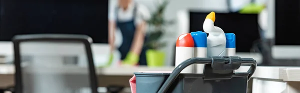 Panoramic shot of cart with different cleaning supplies used by cleaning company workers — Stock Photo