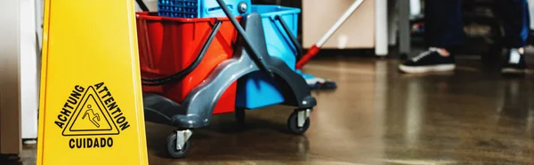 Cropped view of cleaner washing floor near cart with buckets, panoramic shot — Stock Photo