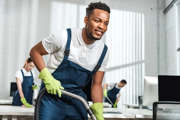 Overhead view of young cleaner cleaning floor in office — Stock Photo