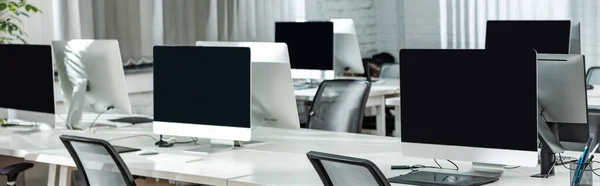 Panoramic shot of open space office with computer monitors on white desks — Stock Photo