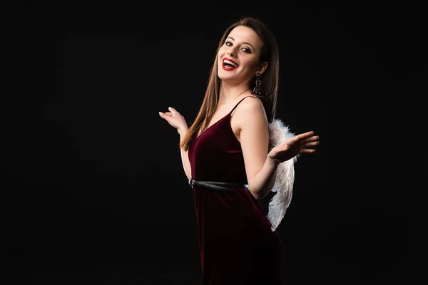 Smiling woman in dress with wings looking at camera isolated on black — Stock Photo