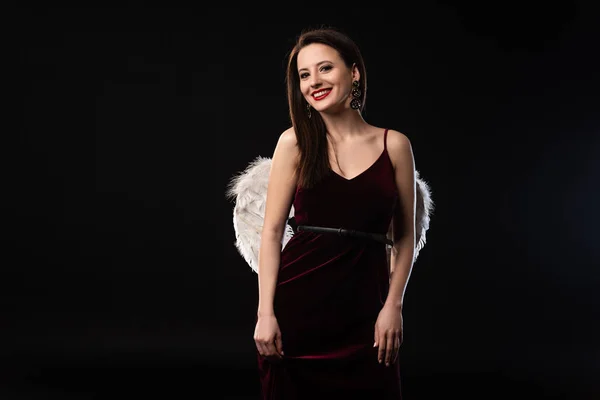 Smiling woman in dress with wings looking at camera isolated on black — Stock Photo